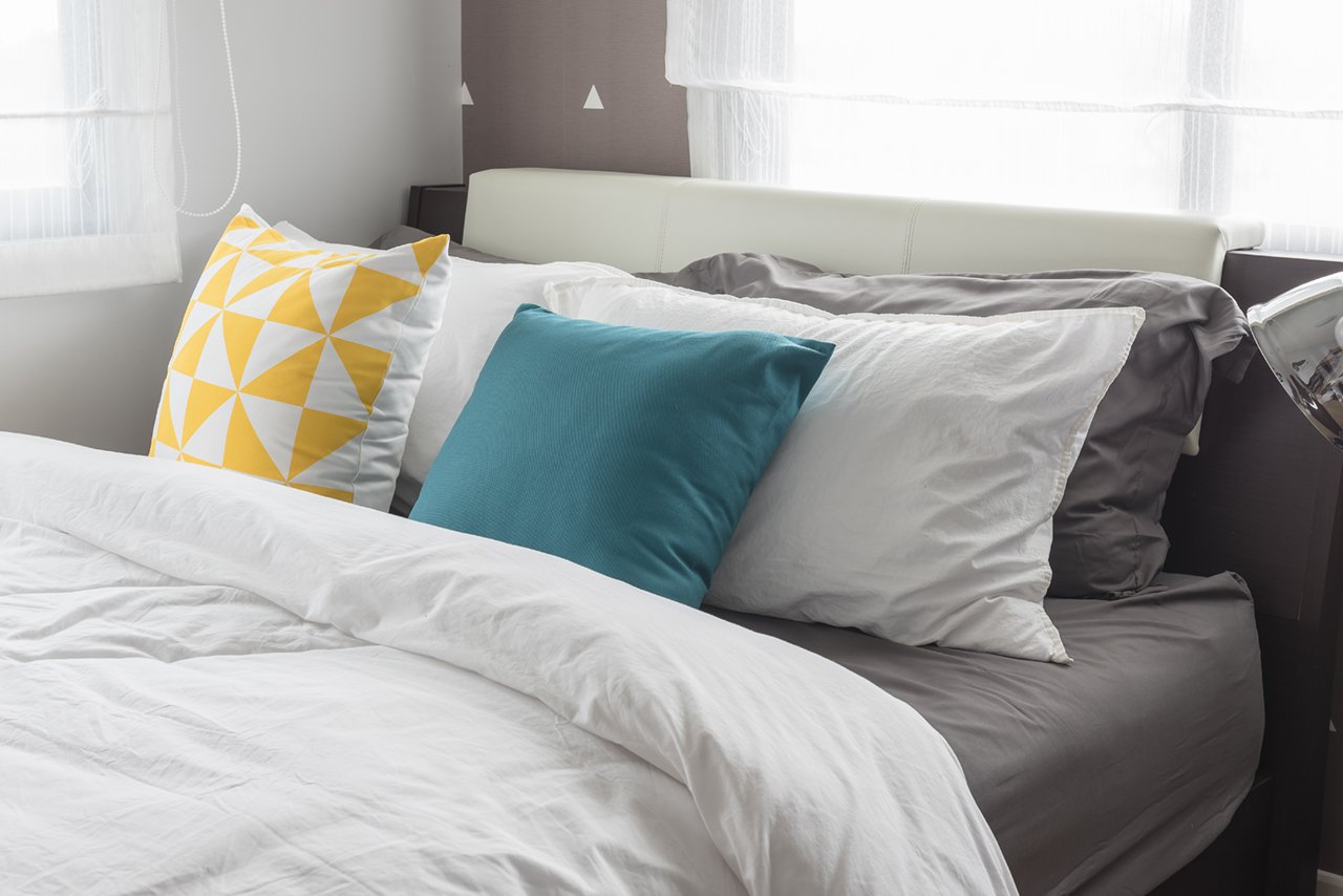 colorful-pillows-on-white-bed-in-modern-bedroom